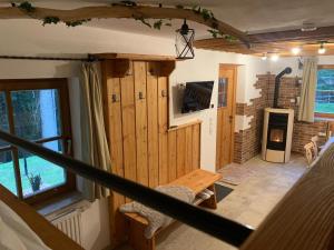 a living room with a fireplace and a wooden wall at Bergchalet Zirbenzapfen in Judenburg