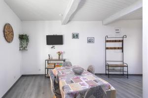 a room with a table with chairs and a tv at Logis Du Roussillon in Bélesta