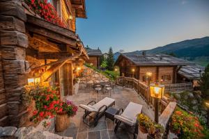 an outdoor patio with chairs and tables and a building at Le Chalet Suite Livigno in Livigno