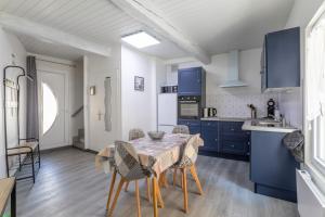 a kitchen with blue cabinets and a table and chairs at Logis Du Roussillon in Bélesta