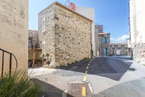 an alley with a stone building on the side of a street at Logis Du Roussillon in Bélesta
