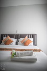 a bed with orange and white pillows and a table at Retro Twin Home @Maesot in Mae Sot