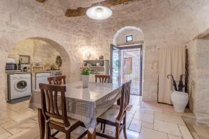 a kitchen with a table and chairs in a room at Trullo Cielo Cielo in Alberobello