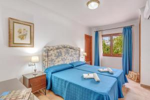 a bedroom with a blue bed and a window at Villa Pintor in Port de Pollensa +19 photos