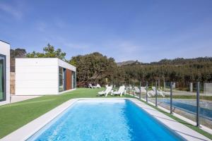 a swimming pool in the backyard of a house at Complejo Bungalow con piscina in A Pobra do Caramiñal