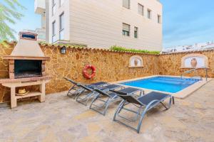 a patio with chairs and a pool and a grill at Villa Pintor in Port de Pollensa