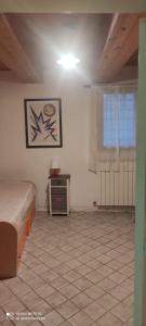 a bedroom with a bed and a table and a window at Elena's Guest House in Urbino
