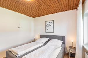a bed in a bedroom with a wooden ceiling at Ferienwohnung Wanderbar in Kamp-Bornhofen