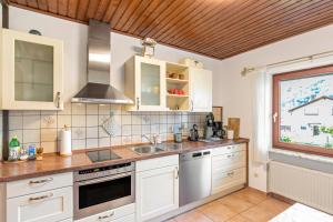 a kitchen with white cabinets and a sink and a window at Ferienwohnung Wanderbar in Kamp-Bornhofen