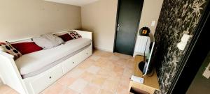 a small room with a white bed with pillows on it at La Maison Des Conches - Ref 803 in Longeville-sur-Mer