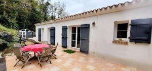 a patio with a table and chairs and a house at La Maison Des Conches - Ref 803 in Longeville-sur-Mer