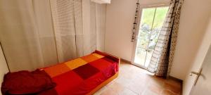 a bedroom with a colorful bed in front of a window at La Maison Des Conches - Ref 803 in Longeville-sur-Mer +5 photos