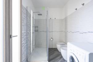 a white bathroom with a shower and a toilet at Appartamento Latorre in Bari Sardo