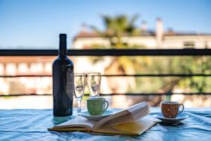 a table with a wine bottle and two glasses and a book at Appartamento Latorre in Bari Sardo +12 photos