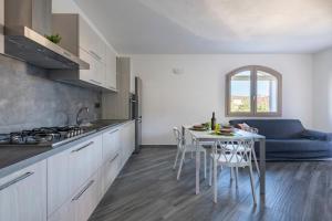 a kitchen with a table and a blue couch at Appartamento Latorre in Bari Sardo