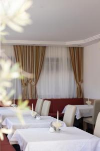 a dining room with white tables and white chairs at Kleon 4 in Rifiano +24 photos