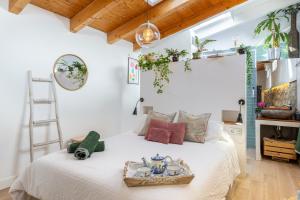 a bedroom with a white bed with a ladder at Apto Rural La Buganvilla in Valdelaguna
