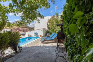 a pool with two lounge chairs next to a building at Apto Rural La Buganvilla in Valdelaguna