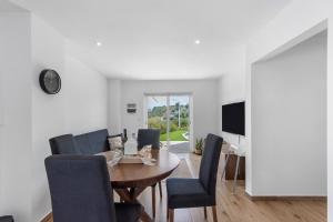 a dining room with a table and chairs and a television at Refugio Das Vinhas in Celorico de Basto