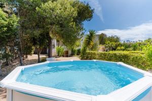 a large plunge pool in a yard with trees at Villa Camilla a Otranto in Otranto
