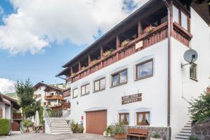 a white building with flowers on the balcony at Pension Sonia App 104 in Funes