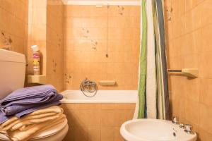 a bathroom with a toilet and a sink and a tub at Pension Sonia App 104 in Funes +16 photos