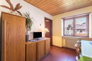 a living room with a television on a wooden cabinet at Pension Sonia App 104 in Funes