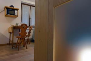 a room with a table and a chair and a microwave at Petit Bijou Morgex in Morgex +3 photos