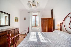 a bedroom with a bed and a chandelier at Col Di Metino - Umbria in Gualdo Tadino