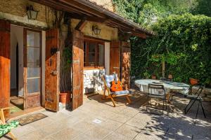 a patio with a table and chairs and a guitar at Col Di Metino - Umbria in Gualdo Tadino