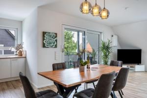 a dining room with a wooden table and chairs at Ferienhaus Ebringen in Ebringen