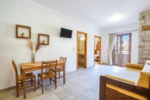 a dining room and living room with a table and chairs at Petra Studios in Karpathos