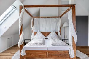 a bedroom with a canopy bed with pillows at Ferienhaus Ebringen in Ebringen