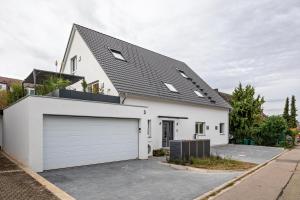 a white house with a garage at Ferienhaus Ebringen in Ebringen