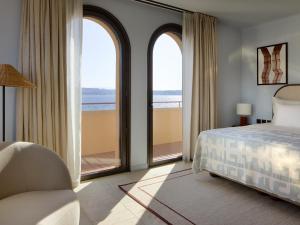 a bedroom with a bed and a view of the ocean at Zannier Île de Bendor in Bandol +107 photos