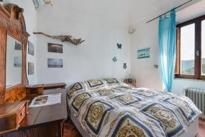 a bedroom with a bed with a dresser and a desk at Nadine - Bilocale In Centro in Marciana