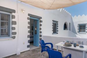 a room with a table and chairs and a blue door at Pico Bello Patmos 30 in Patmos