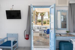a room with a blue door and a table and chairs at Pico Bello Patmos 30 in Patmos