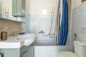 a bathroom with a sink and a toilet and a shower at Andros Traditional House in Andros