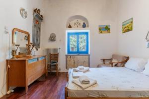 a bedroom with a bed and a dresser and a mirror at Andros Traditional House in Andros