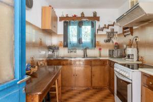 a kitchen with wooden cabinets and a sink at Andros Traditional House in Andros