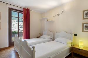 two white beds in a room with a window at Maison Gnemaz Grand Combin in Aosta