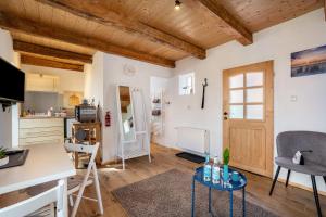 a kitchen and living room with wooden ceilings at Bezauberndes Lütt Hus in Damlos