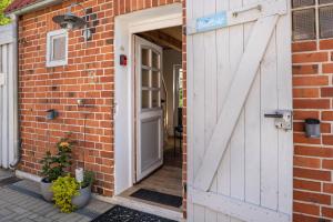 an open door to a brick house with a brick wall at Bezauberndes Lütt Hus in Damlos