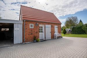 a small brick building with a red roof at Bezauberndes Lütt Hus in Damlos