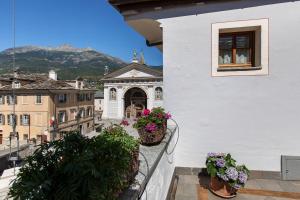 a balcony with potted plants and a building at Maison Gnemaz Grand Combin in Aosta