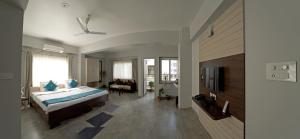 a bedroom with a bed and a tv in a room at Happy Villa Guest House in Guwahati