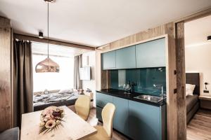 a kitchen and living room with a table and a couch at Mysciliar Apartment Tree ii in Siusi