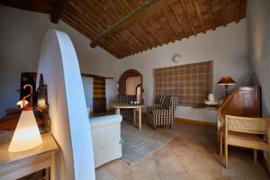 a living room with a surfboard and a bedroom at Agriturismo Petra in Suvereto
