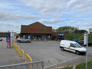 a store with cars parked in a parking lot at Sunnymede G20 with Hot Tub - pet friendly, Wifi, bed linen - Meadow Lakes Caravan & Lodge Hire in Ingoldmells